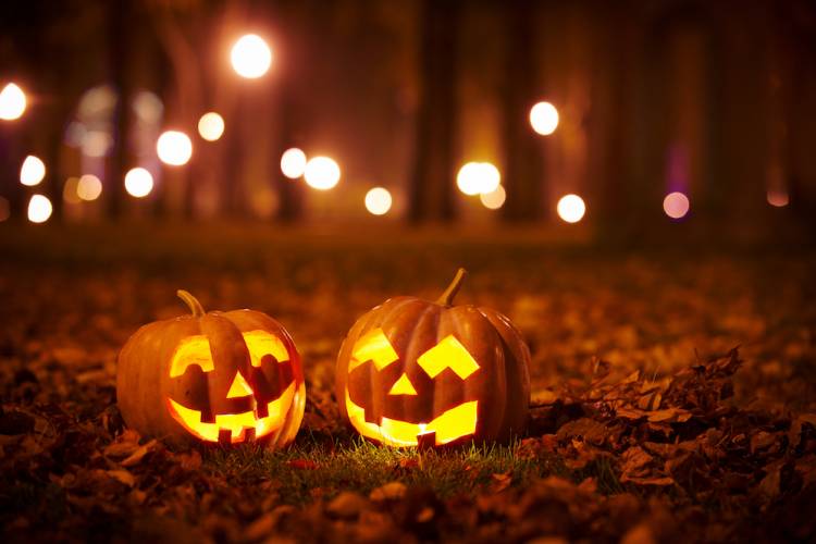 jack-o-lanterns in leaves at night